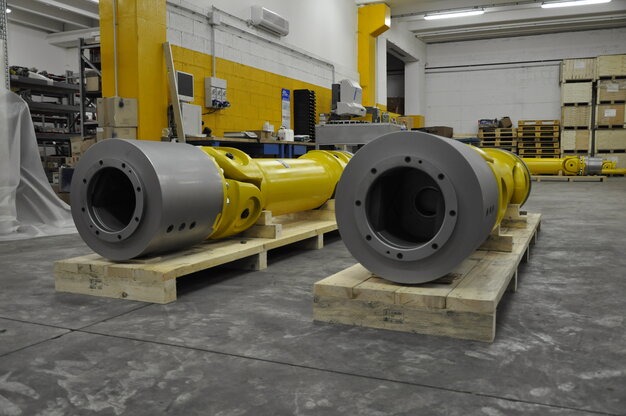 Yellow cardan shafts with grey terminals on pallet in EPR workshop